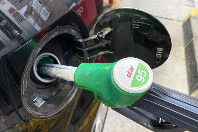 Surtidor de gasolina 95 insertado en el depósito de un vehículo durante el repostaje en una estación de servicio