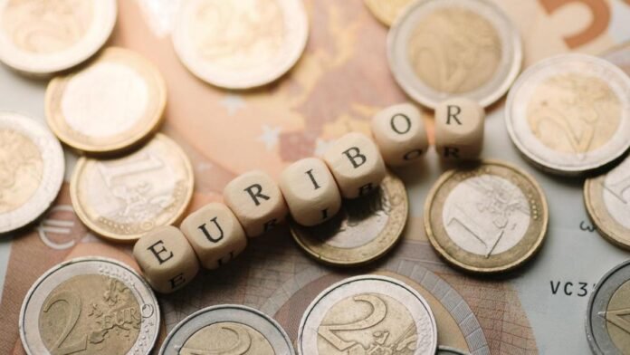 Monedas de euro rodeando bloques de letras que forman la palabra 