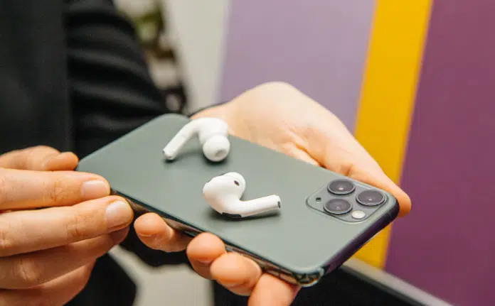 Nuevos AirPods blancos sobre un iPhone 11 Pro con fondo colorido, mostrando la integración de los productos Apple