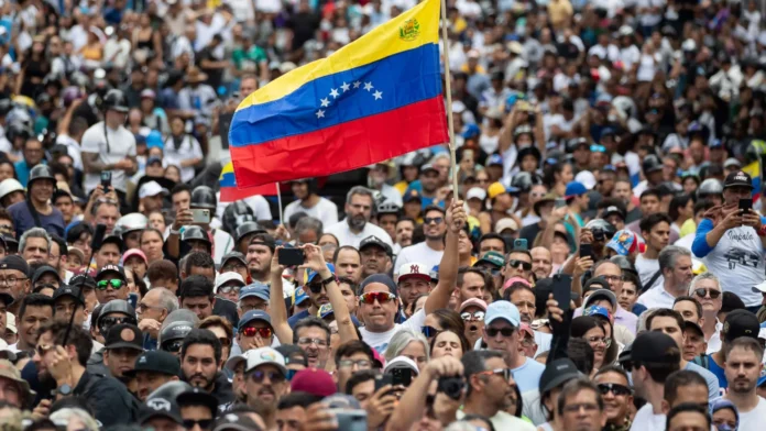 Multitud en protesta venezolana con bandera nacional ondeando, exigiendo transparencia electoral