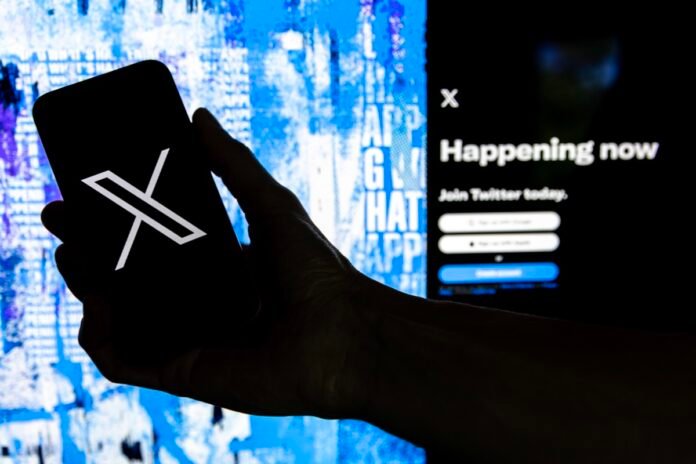 Smartphone mostrando logo de X frente a pantalla de inicio de sesión, simbolizando la transformación digital de Twitter.