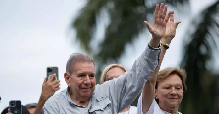 Edmundo González, líder opositor venezolano, saluda con los brazos en alto junto a su esposa en un acto público