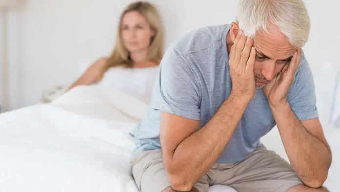 Pareja mayor enfrentando problemas de intimidad debido a la disfunción eréctil, hombre angustiado sentado al borde de la cama.