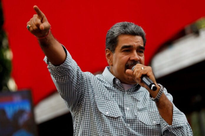 Nicolás Maduro, presidente de Venezuela, dando un discurso enérgico en un mitin político con fondo rojo