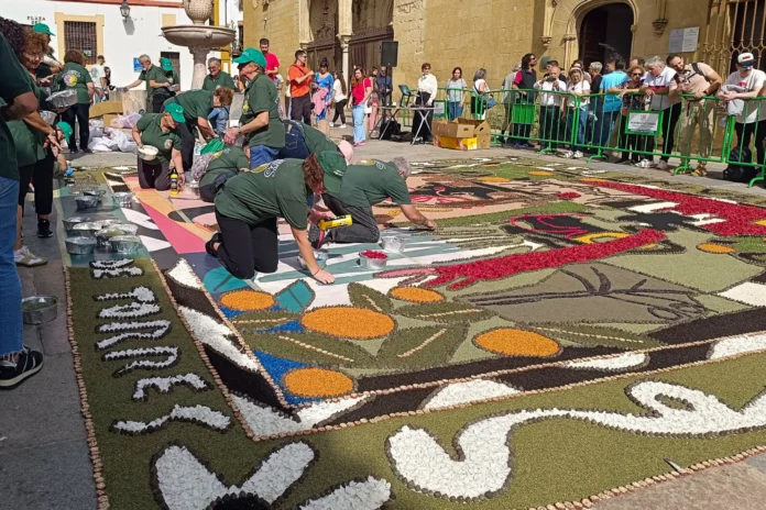 Artesanos trabajando en una colorida alfombra floral durante el festival Flora en Córdoba